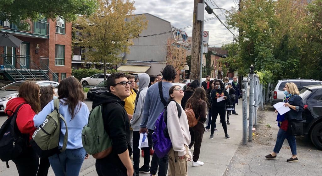 Students on trip looking up at street art